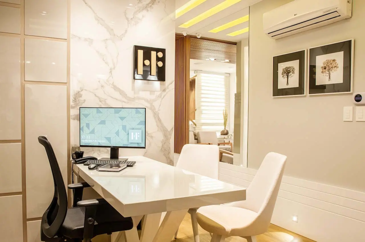 Home office with marble-patterned wallpaper and a PC on the desk.