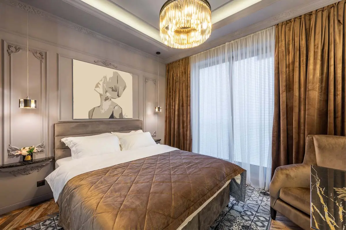 Elegant bedroom with brown soundproof curtains and white sheer drapes.