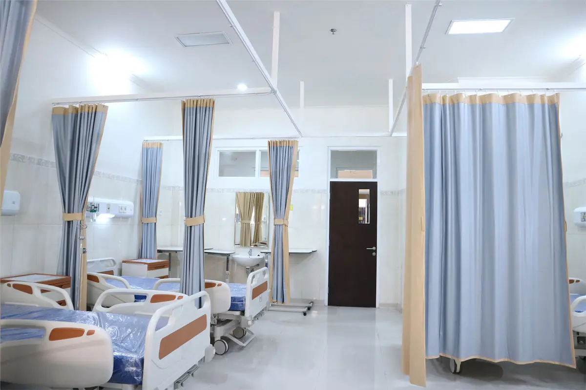 Hospital room with privacy curtains around patient beds.