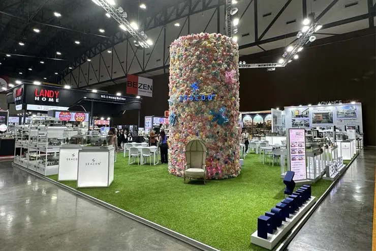 Landy Home stall at the Expo with a decorative column with lots of flowers around it.