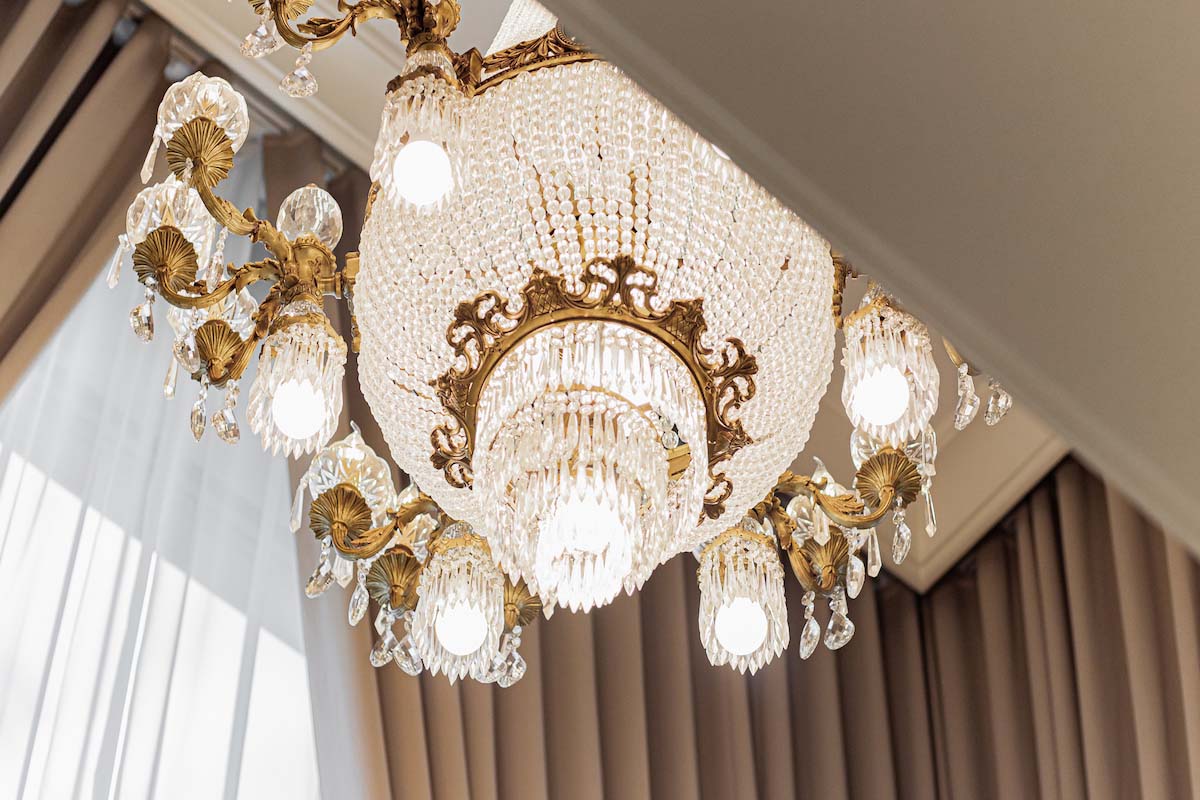 Luxurious Chandelier with Drapery at Background.