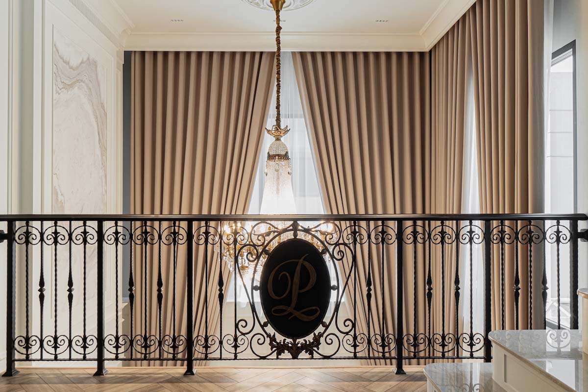 Ornate Balustrade Overlooking Foyer and Stylish Curtains.