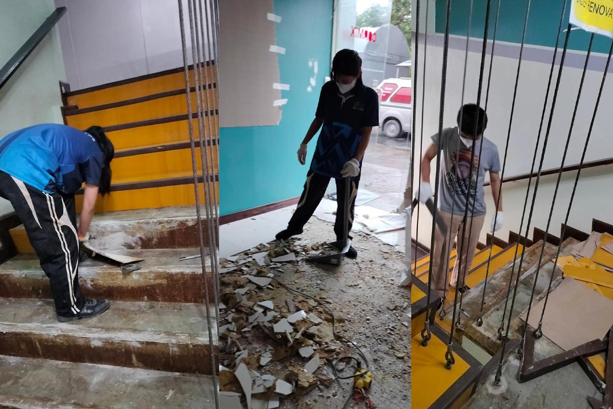Team removing old flooring and stair coverings at Cormix Bangkok office to prepare for complete renovation.