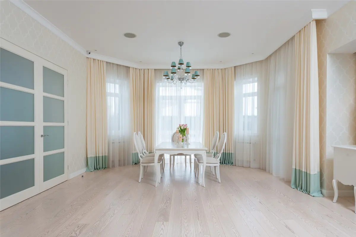 Elegant dining room with light dimout curtains and classic furniture.