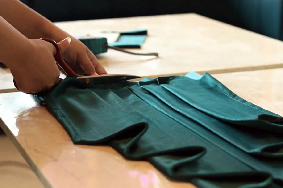 Lady crafting green colored velvet curtains for Swag and Tail Style.