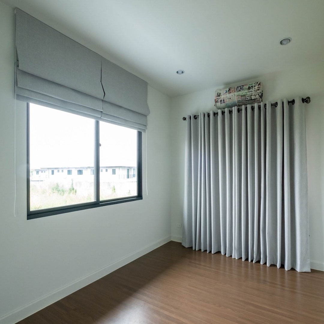 Gray color Roman shades and blackout curtains.