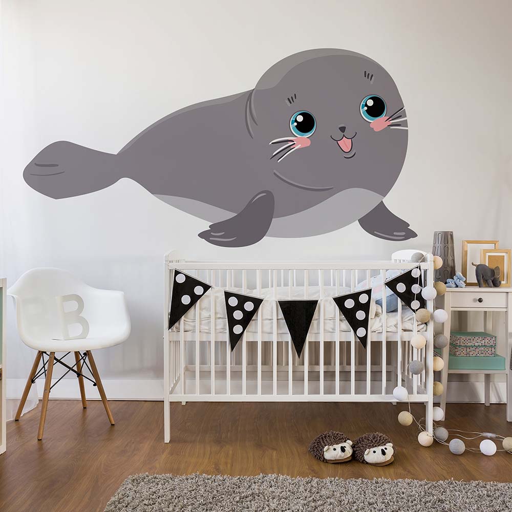 Adorable sea lion wallpaper in a cozy baby nursery setup.