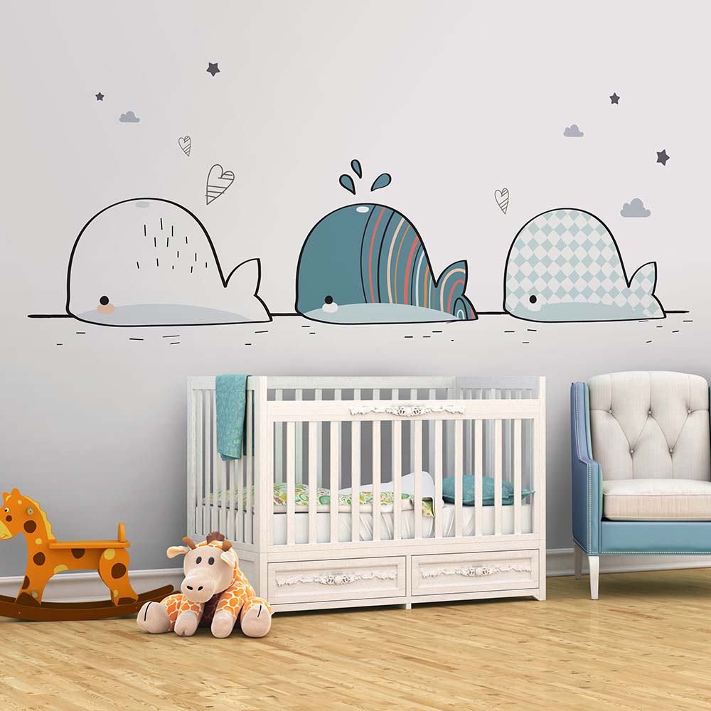 Cartoon whale wallpaper adding charm to a baby's nursery.