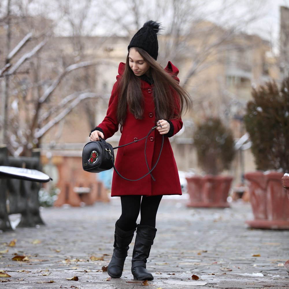 Woman in Red Coat Holding Shanli Handmade Black Leather Bag.