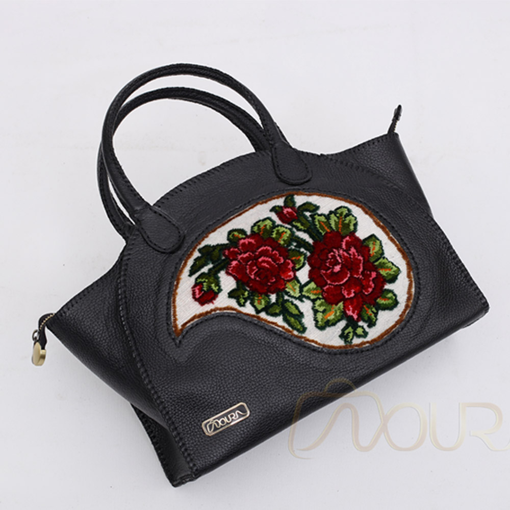 Black leather bag with red rose embroidery carpet.