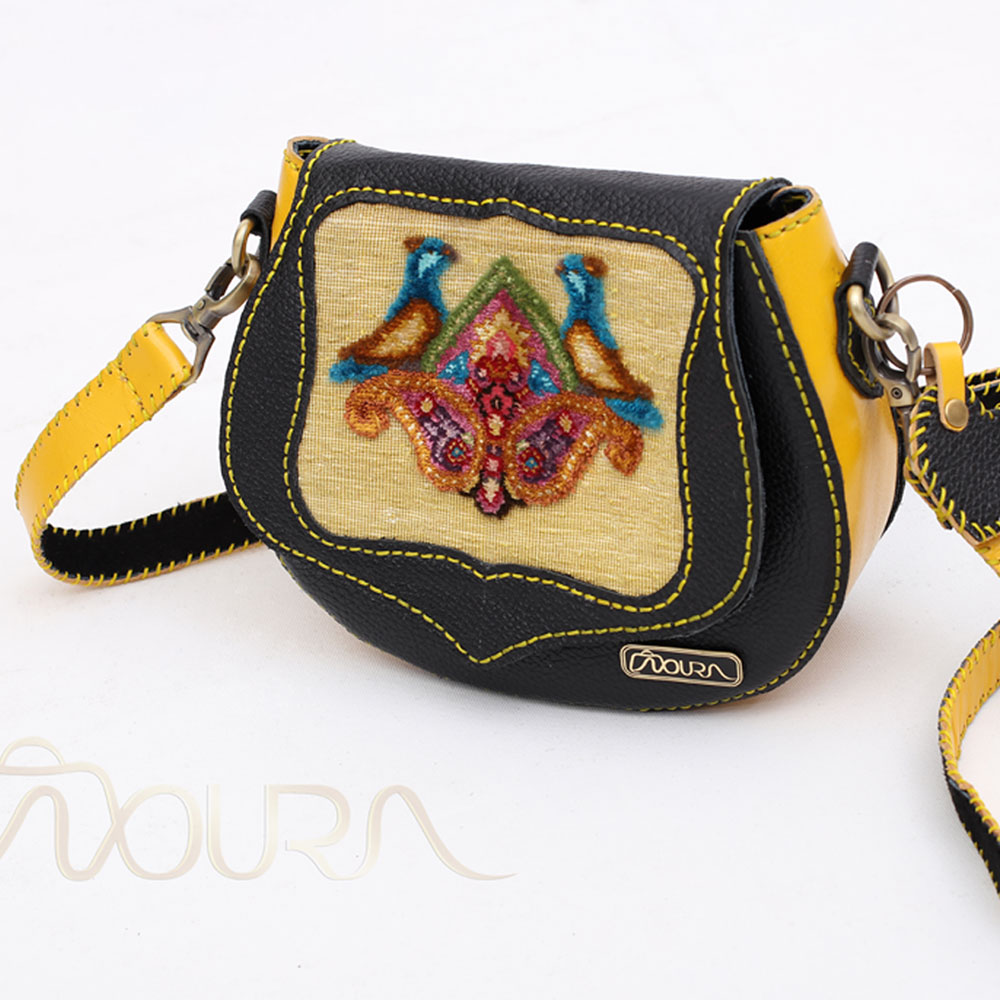 Yellow-and-black crossbody bag with woven small carpet on it.