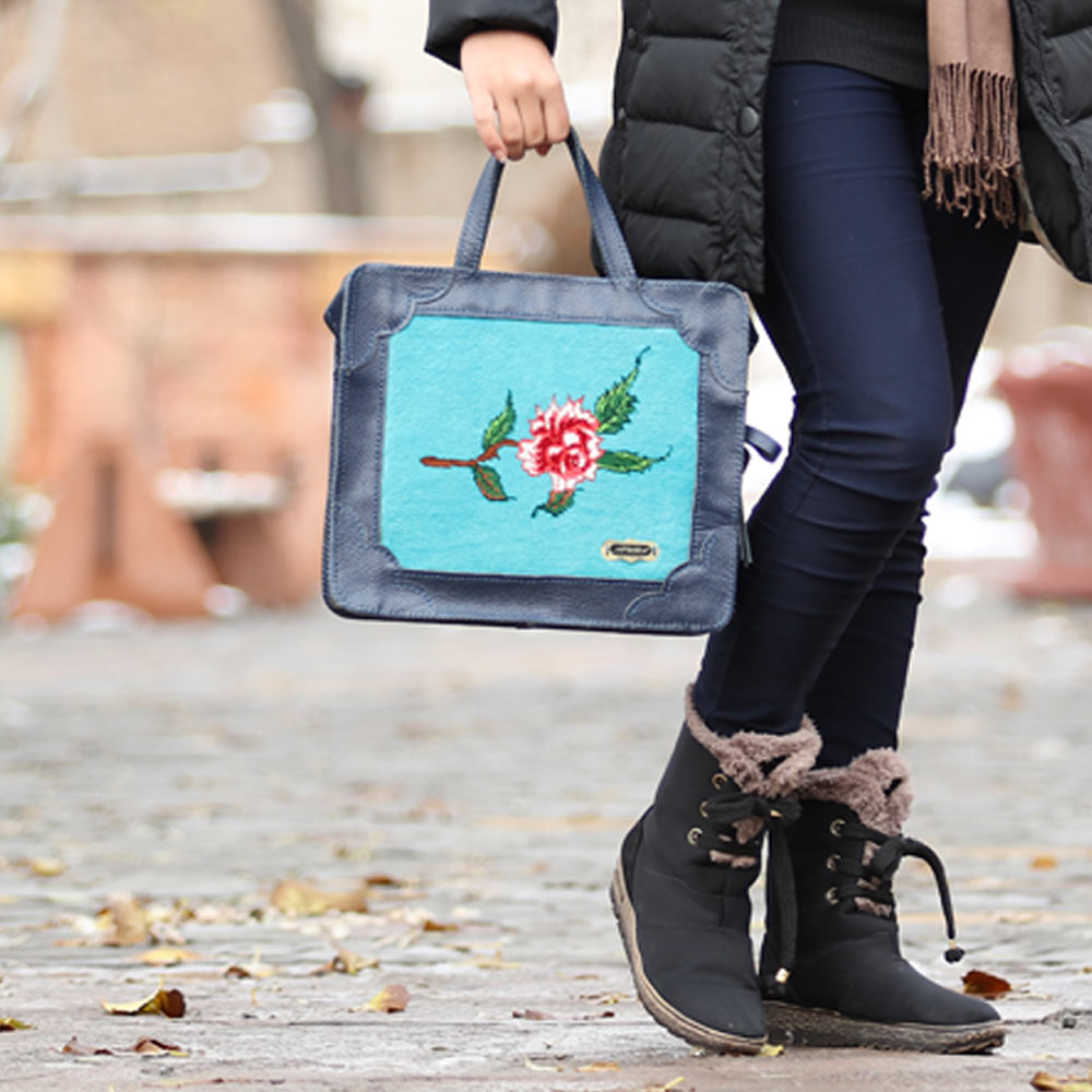 Blue leather handmade women bag with floral carpet pattern on it.