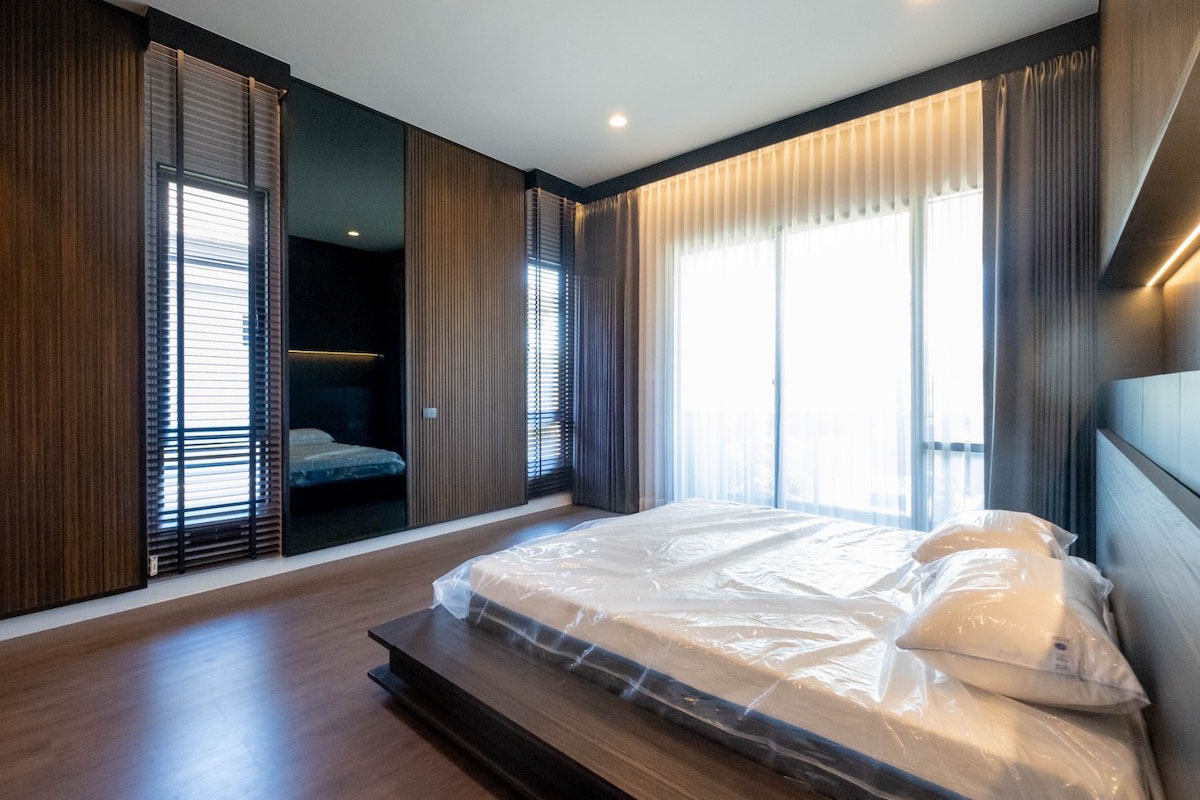 Bedroom with layered sheer and dimout curtains.