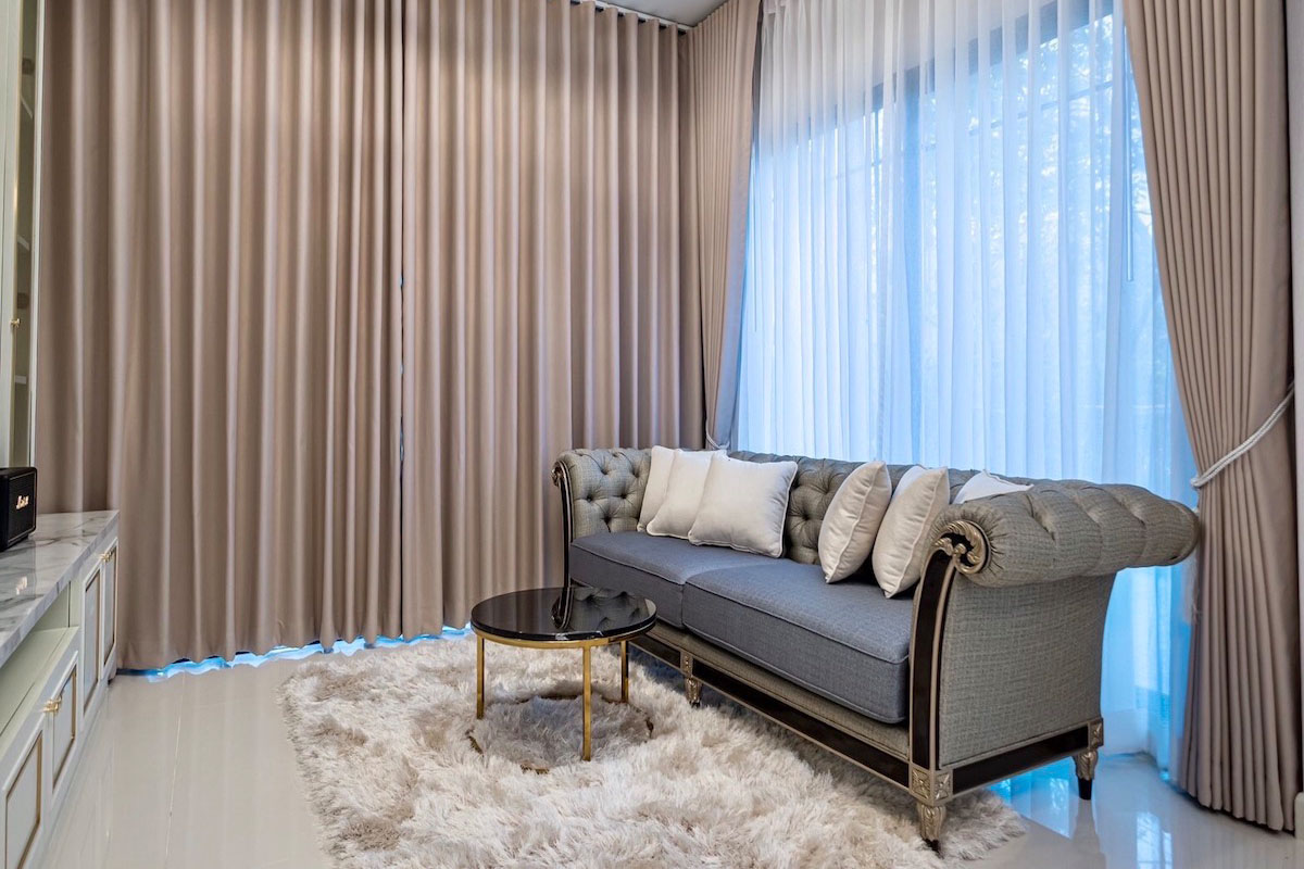 Stylish Elegance: Plush Sofa and Layered Curtains.