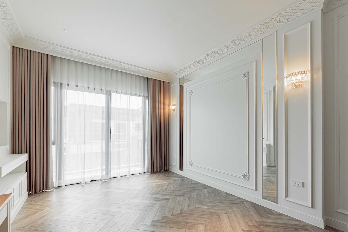 Bedroom adorned with two layer curtains.