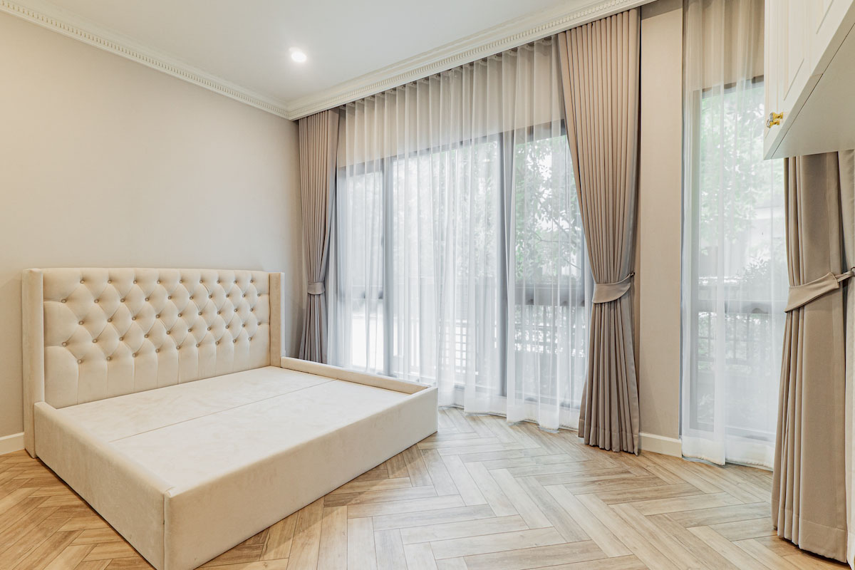 Minimalist Elegance: Neutral Tones and Sheer Curtains in a Contemporary Bedroom.
