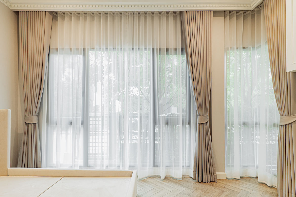 Soft Sheers and Luxurious Drapes in a Bedroom.