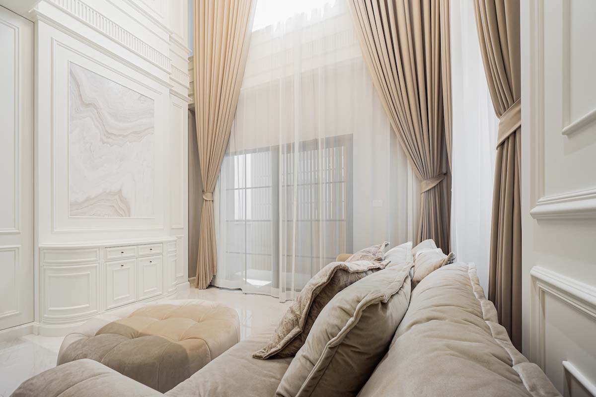 Plush Comforts and Graceful Curtains in a Bright, Airy Room.
